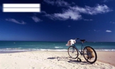自行车停在蓝天白云下的海滩上图片